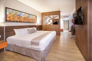 a hotel room with a bed and a flat screen tv at Metria Hotel in León