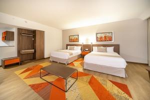 a hotel room with two beds and a table at Metria Hotel in León