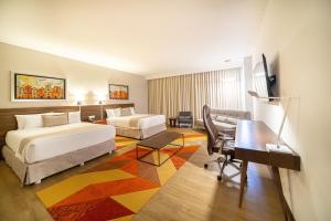a hotel room with two beds and a desk at Metria Hotel in León