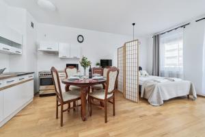 a kitchen and dining room with a table and chairs at Apartments Wrocław Bajana by Renters in Wrocław