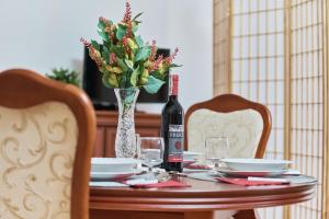 a table with a bottle of wine and a vase of flowers at Apartments Wrocław Bajana by Renters in Wrocław