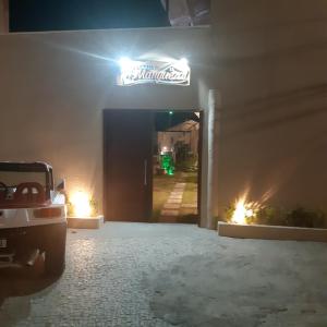 a entrance to a garage at night with a neon sign at Pousada Manguezal in Icaraí