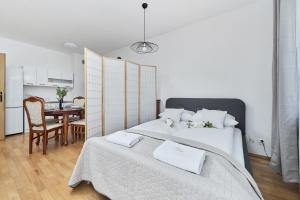 a bedroom with two beds and a table and a kitchen at Apartments Wrocław Bajana by Renters in Wrocław