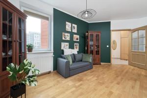 a living room with a couch and a green wall at Apartments Wrocław Bajana by Renters in Wrocław