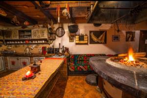 - une cuisine avec foyer extérieur dans une pièce dans l'établissement Casa de hodina Maria, à Sângeorz-Băi