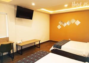 a hotel room with a bed and a desk and a tv at Hotel25 in Monterrey