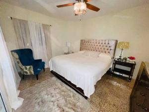 a bedroom with a bed and a blue chair at Dulce hogar del sur, con estacionamiento gratis in Baní