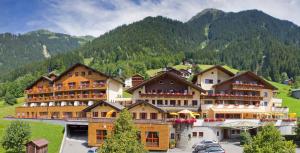 a hotel in the mountains with mountains in the background at Berg-Spa & Hotel Zamangspitze in Sankt Gallenkirch