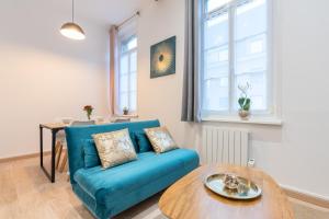 a living room with a blue couch and a table at Blue Bail - T2 au calme - proche commerces in Douai