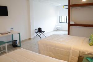 Postel nebo postele na pokoji v ubytování Hotel & Suites Arges - Centro Chetumal