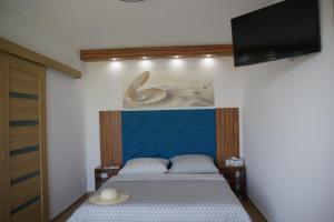 a bedroom with a bed and a flat screen tv at Holiday Amber - in Niechorze