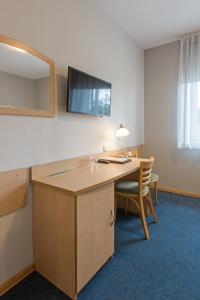 ein Büro mit einem Schreibtisch mit einem Spiegel und einem Stuhl in der Unterkunft Hotel Łabędy in Gliwice