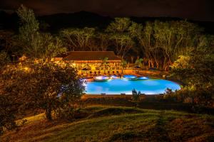 een zwembad voor een huis 's nachts bij Hotel Nana in Villeta