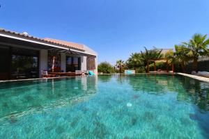 une grande piscine d'eau bleue en face d'une maison dans l'établissement Beautiful Algarve Pool Villa Bali 15min to beach, à Mexilhoeira Grande