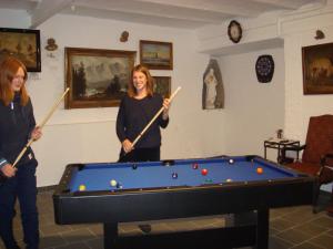 two women playing a game of pool with cue sticks at Historischer Winzerverein Boutique B&B in Senheim