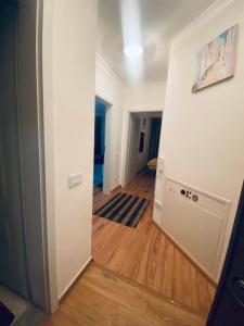 un corridoio con una camera con pareti bianche e pavimenti in legno di 1 Bedroom flat a Kosovo Polje