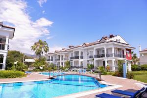 a villa with a swimming pool and a building at Legend Apartments II Fethiye in Fethiye