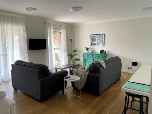 a living room with two couches and a table at Kiama Palms on Terralong in Kiama