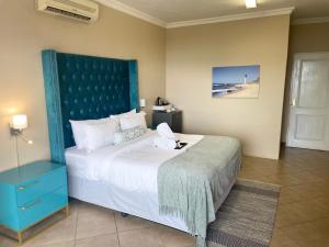 Un dormitorio con una cama grande con cabecero azul. en Boat Yard Guest House, en Hartbeespoort