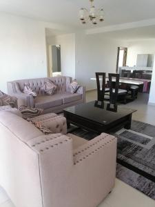 a living room with two couches and a table at Astoria apartments in Nairobi