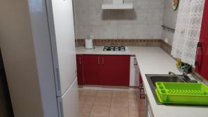 a kitchen with red cabinets and a green tray on the counter at Casa Babuche in Algar
