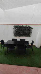 einem schwarzen Tisch und Stühlen mit einer Pflanze an der Wand in der Unterkunft Casa Babuche in Algar