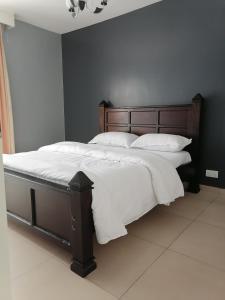 a bed with white blankets and pillows in a bedroom at Astoria apartments in Nairobi