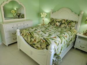 a bedroom with a white bed and two dressers and a mirror at Breathtaking Villa At The Crest in Richmond