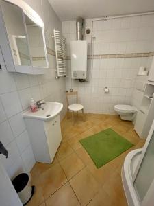 a white bathroom with a sink and a toilet at Apartament pod Stożkiem in Sokołowsko