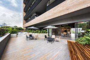 un patio con sedie e tavoli su un edificio di Go Living and Suites - Jalo Rent a Medellín
