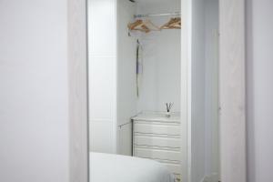 a white bedroom with a bed and a dresser at Loft en el corazón de Cádiz con opción a Parking in Cádiz