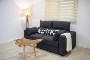 a living room with a blue couch and a table at Loft en el corazón de Cádiz con opción a Parking in Cádiz