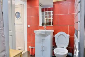 a bathroom with a toilet and a sink and red tiles at The paraglider of Crolles #CP in Lumbin