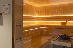a bathroom with a shower with wooden walls at Hotel Caprice - Grindelwald in Grindelwald