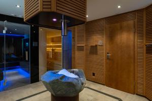 a room with a rock in the middle of a building at Hotel Caprice - Grindelwald in Grindelwald +37 photos