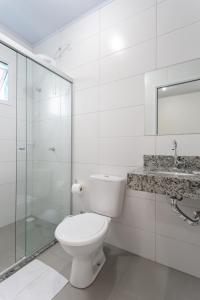 een witte badkamer met een toilet en een wastafel bij Galileia flat in Santa Maria