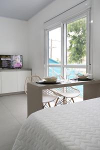 Un dormitorio con una cama y una mesa con sillas. en Galileia flat, en Santa Maria