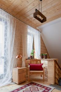 a room with a chair and a table and a window at PUSTELNIA WODZA in Wisła