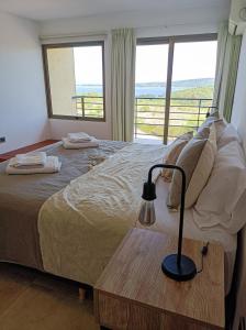 a bedroom with a bed with a view of the ocean at Solar de Roca in Embalse