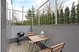 a patio with a table and a grill on a balcony at Villa Arkodes in Gdańsk
