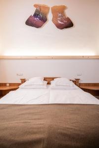 uma cama com três pares de meias penduradas na parede em Hotel Hurtmuehle Kronblick em San Lorenzo di Sebato