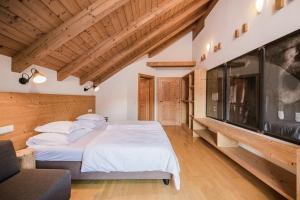 um quarto com uma cama grande e uma televisão de ecrã plano em Hotel Hurtmuehle Kronblick em San Lorenzo di Sebato