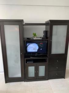 a entertainment center with a tv and two glass doors at RECOLETA STUDIO in Buenos Aires