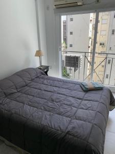 a large bed in a bedroom with a large window at RECOLETA STUDIO in Buenos Aires