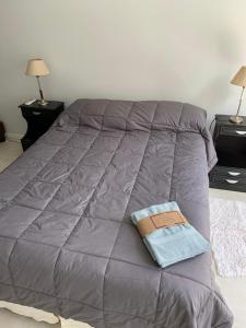 a bed with a purple comforter and a book on it at RECOLETA STUDIO in Buenos Aires