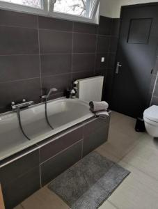 a bathroom with a bath tub and a toilet at LA SUITE 159 in Namur