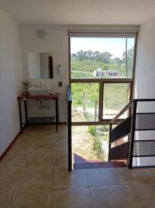 a bathroom with a sink and a large window at Solar de Roca in Embalse
