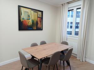 a dining room with a wooden table and chairs at URDAIHOME in Guernica y Luno