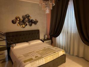 a bedroom with a large bed and a chandelier at Tartaglione in Caserta