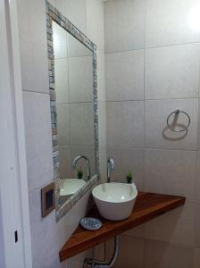 W łazience znajduje się umywalka, wanna i lustro. w obiekcie Solar de Roca w mieście Embalse